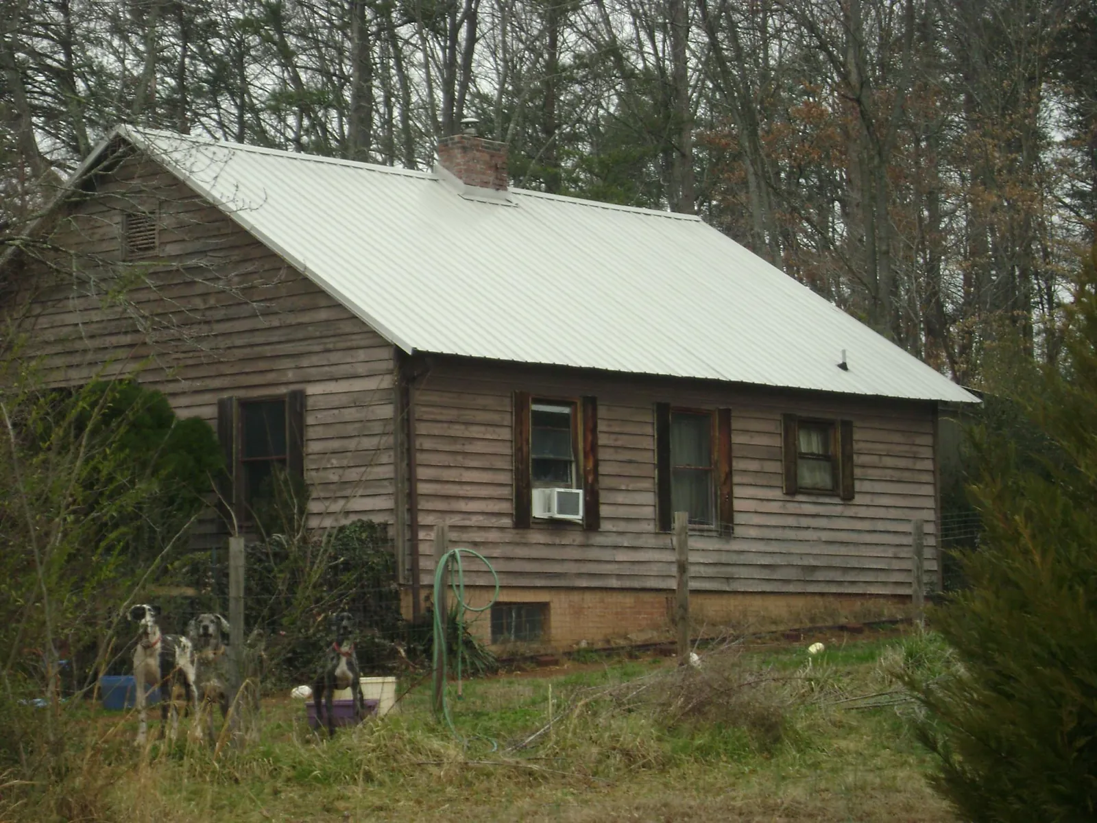 White metal roof on an old wood sided farmhouse, from a Metal Roof Installation job in Bryant